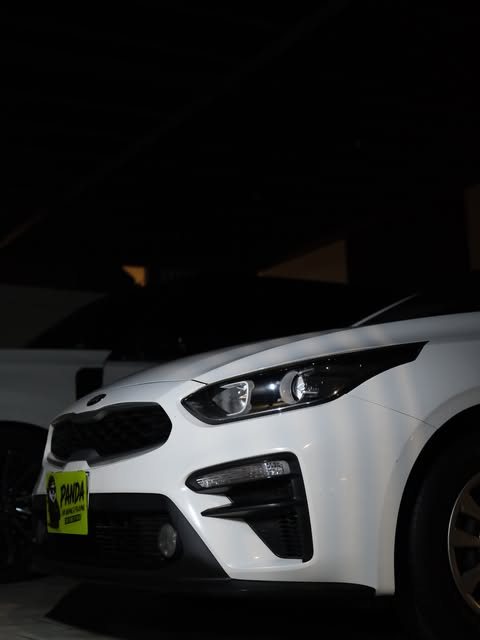 White sedan with a Panda Car Wash plate at night